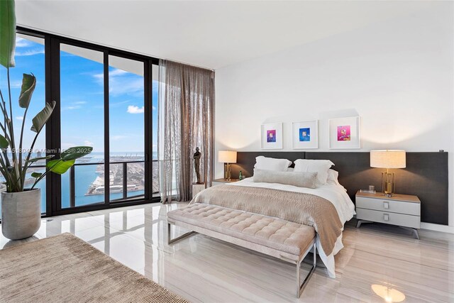 bedroom with expansive windows and a water view