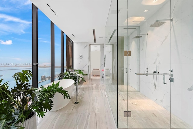 bathroom featuring shower with separate bathtub, a water view, and expansive windows