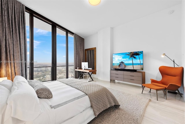 bedroom with hardwood / wood-style floors, floor to ceiling windows, and multiple windows