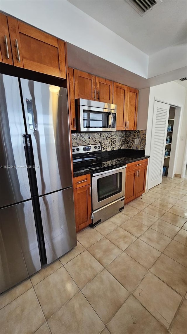 kitchen featuring light tile flooring, tasteful backsplash, and stainless steel appliances