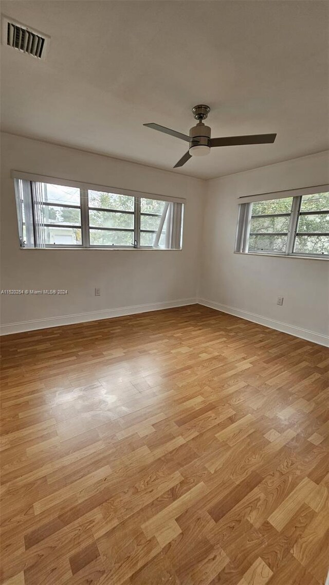 spare room with ceiling fan and light wood-type flooring