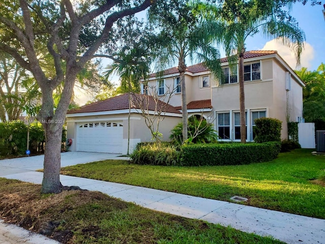 mediterranean / spanish-style home featuring a front yard and a garage