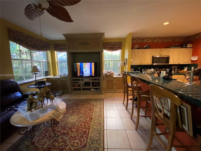 tiled living room with ceiling fan and a wealth of natural light