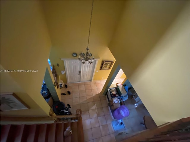 foyer entrance featuring a chandelier, tile floors, and a high ceiling