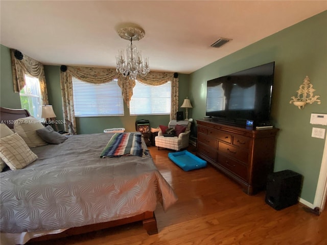 bedroom featuring wood-type flooring and a notable chandelier