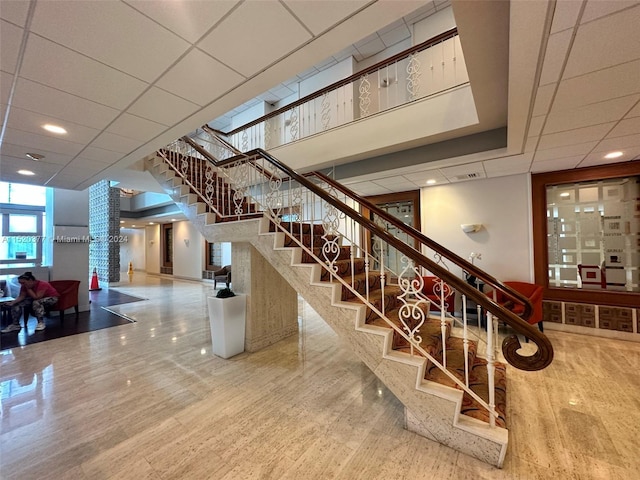 stairs featuring a drop ceiling