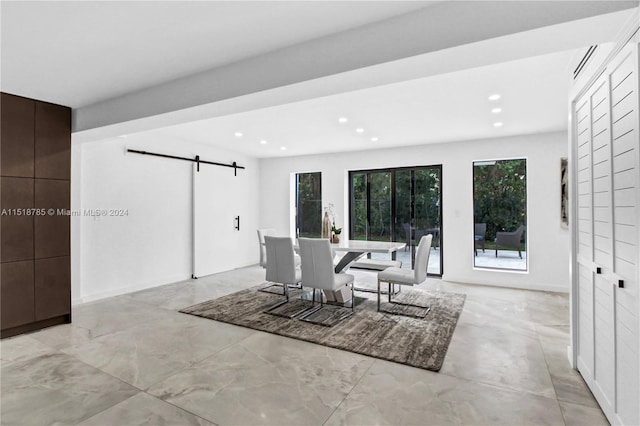 dining space with a barn door and light tile floors