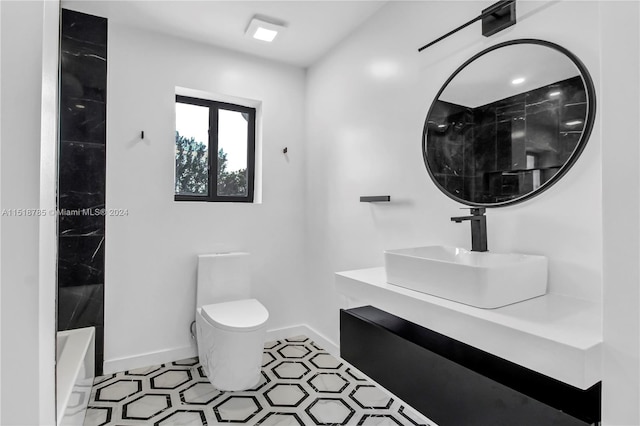 bathroom with tile floors, vanity, and toilet