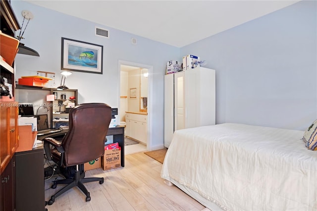 bedroom featuring ensuite bathroom and light hardwood / wood-style floors