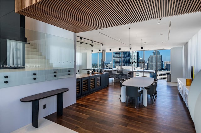 kitchen featuring an island with sink, pendant lighting, floor to ceiling windows, white cabinets, and dark hardwood / wood-style flooring