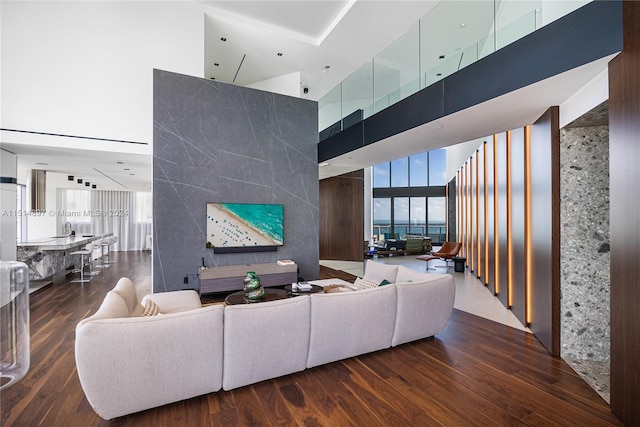 living room featuring dark wood-type flooring and a towering ceiling