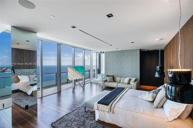 living room with a water view, floor to ceiling windows, and dark hardwood / wood-style floors