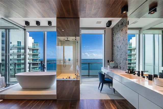 bathroom featuring vanity, a wall of windows, a water view, wooden ceiling, and hardwood / wood-style flooring