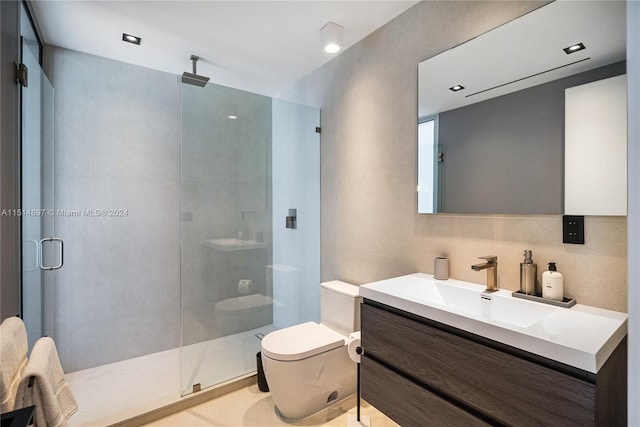 bathroom with toilet, vanity, and a shower with shower door