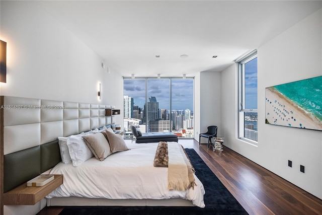 bedroom with access to outside, floor to ceiling windows, and dark hardwood / wood-style floors