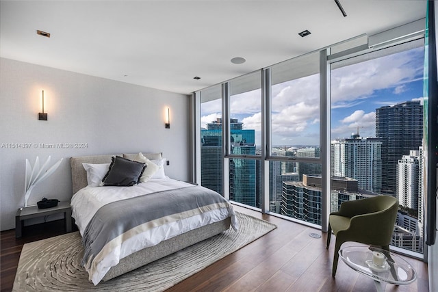 bedroom with floor to ceiling windows and dark hardwood / wood-style floors