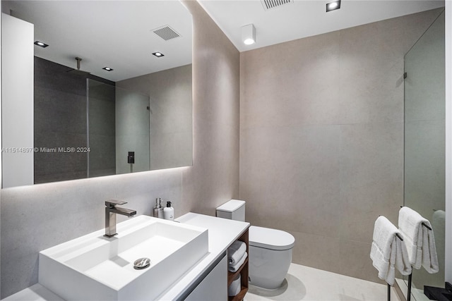 bathroom featuring toilet, vanity, and tile walls