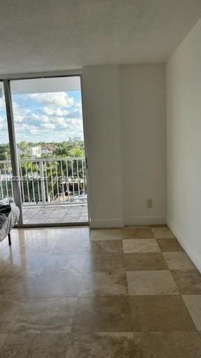 tiled empty room featuring expansive windows