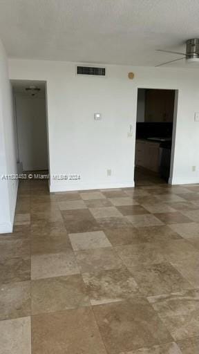 spare room featuring dark tile floors and ceiling fan