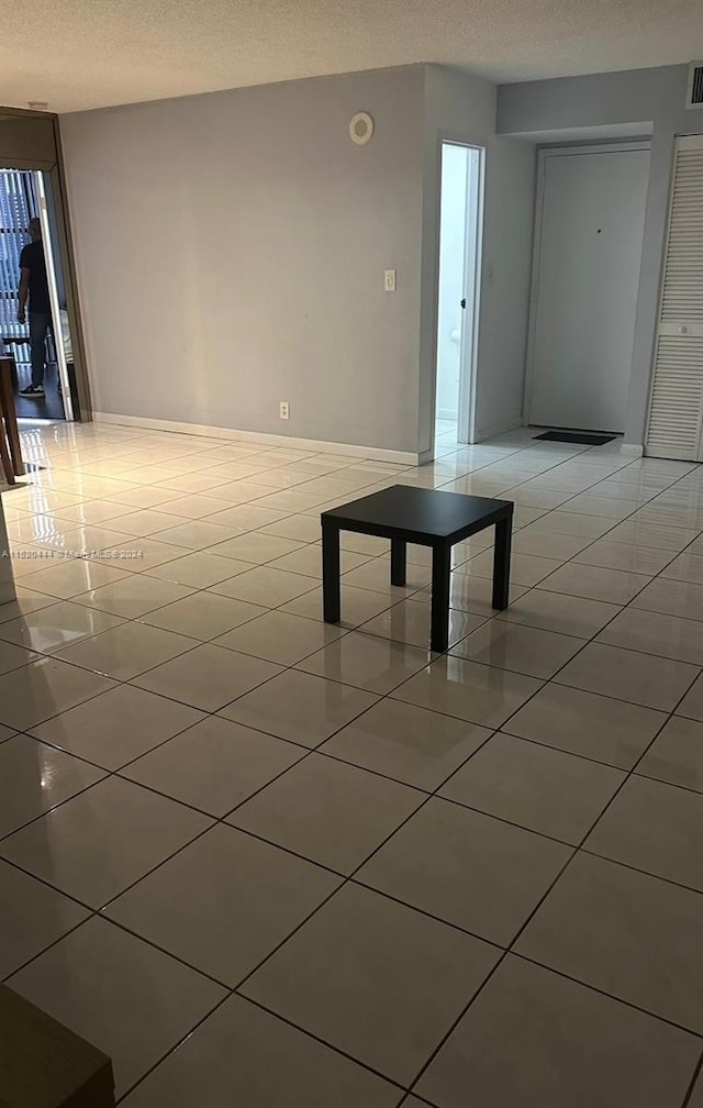 interior space featuring light tile floors and a textured ceiling