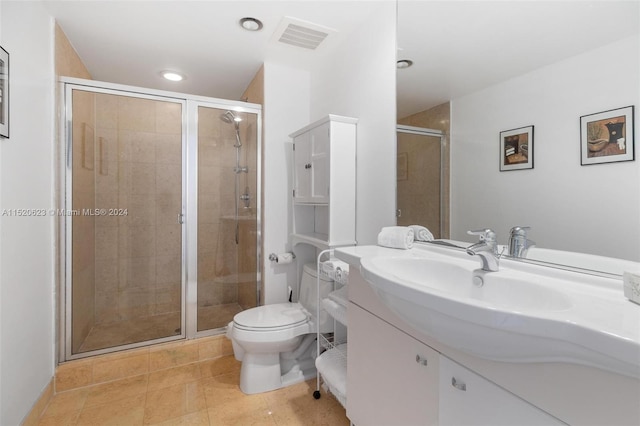 bathroom with a shower with door, tile flooring, large vanity, and toilet