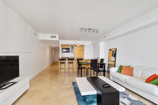 tiled living room featuring track lighting