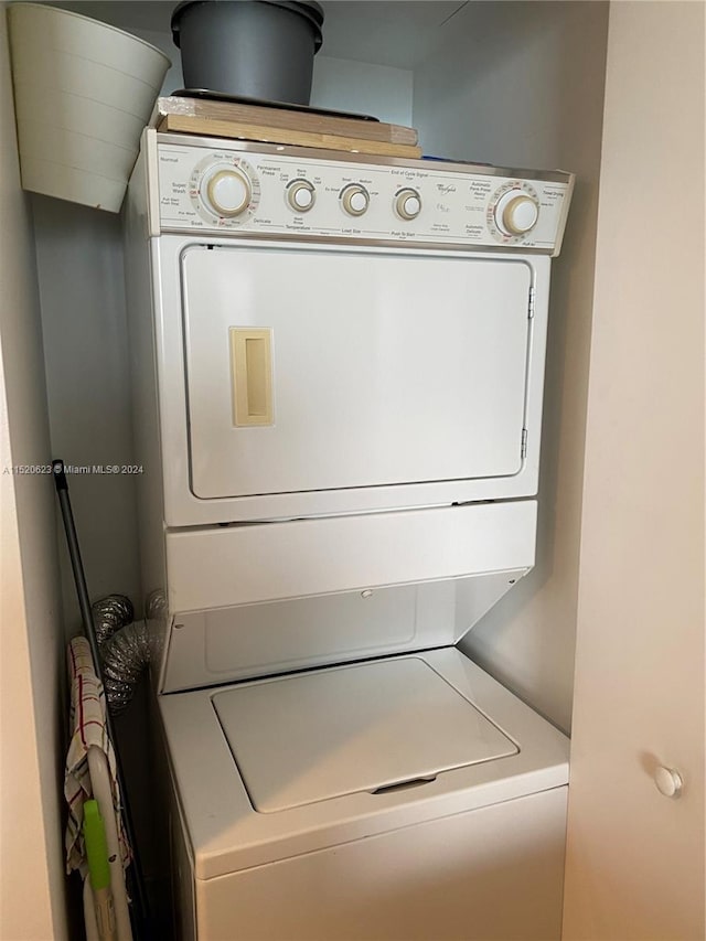 washroom featuring stacked washing maching and dryer