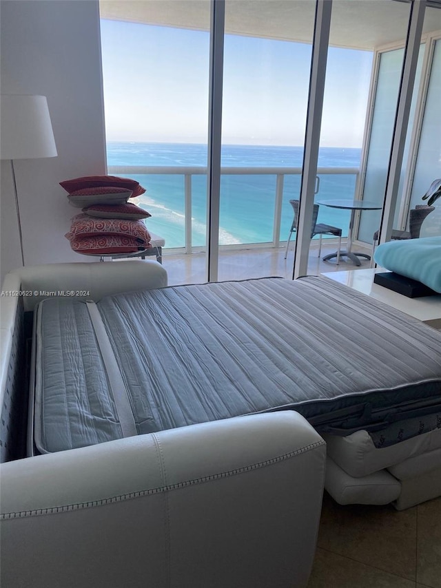 tiled bedroom with a water view and a wall of windows