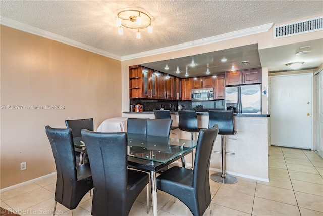 dining room with light tile floors, a textured ceiling, and crown molding