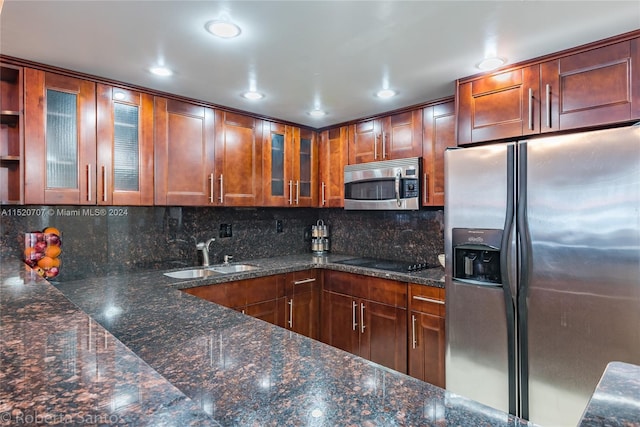 kitchen featuring tasteful backsplash, sink, appliances with stainless steel finishes, and dark stone countertops