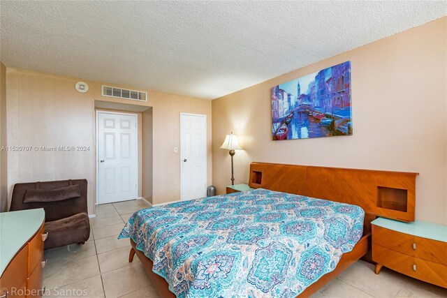 bedroom featuring light tile floors and a textured ceiling