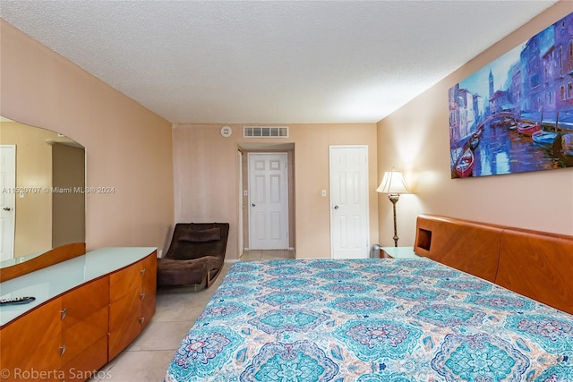 bedroom with light tile floors and a textured ceiling