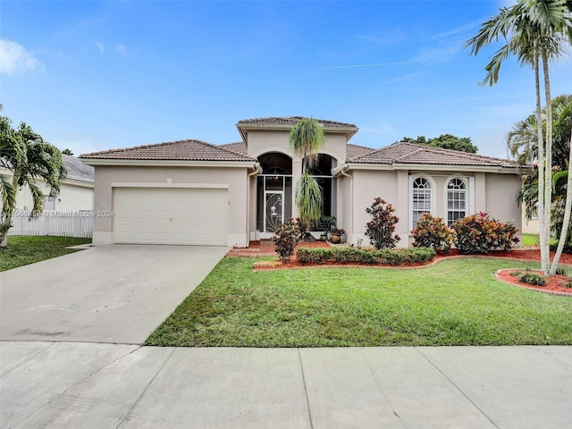 mediterranean / spanish-style house with a front lawn and a garage