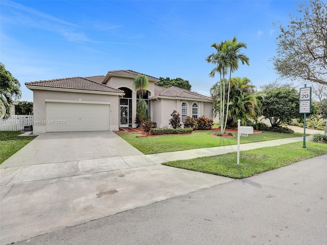 mediterranean / spanish-style house featuring a front yard and a garage