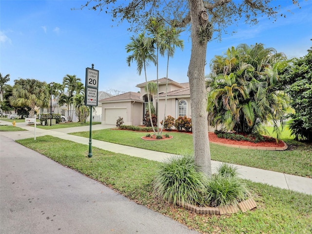 mediterranean / spanish-style home featuring a front yard and a garage