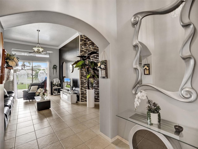 tiled foyer with a notable chandelier and crown molding