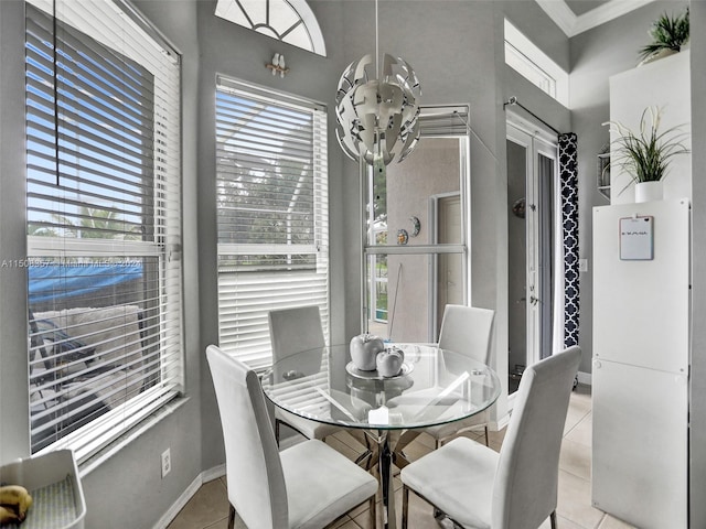 dining area with light tile flooring, ornamental molding, and a healthy amount of sunlight