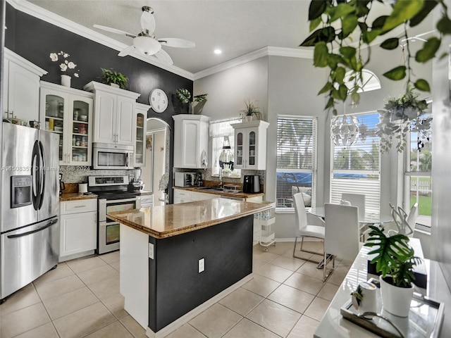 kitchen featuring tasteful backsplash, stainless steel appliances, ceiling fan, and white cabinetry