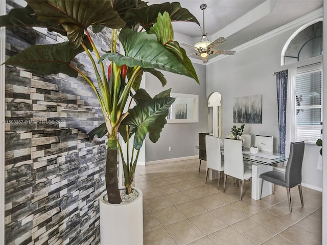 dining room with light tile floors, a raised ceiling, ceiling fan, and crown molding