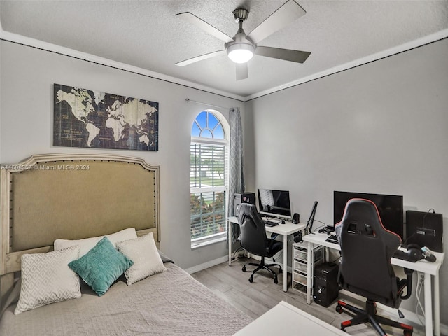 interior space with a textured ceiling, ceiling fan, and light wood-type flooring