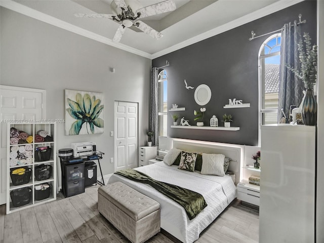 bedroom with ornamental molding, a closet, ceiling fan, and light wood-type flooring