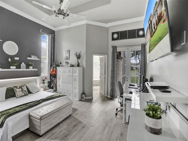 bedroom featuring ceiling fan, french doors, ornamental molding, ensuite bathroom, and light wood-type flooring