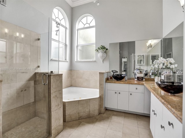 bathroom featuring ornamental molding, tile flooring, double vanity, and separate shower and tub