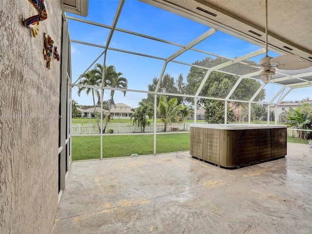 unfurnished sunroom featuring ceiling fan