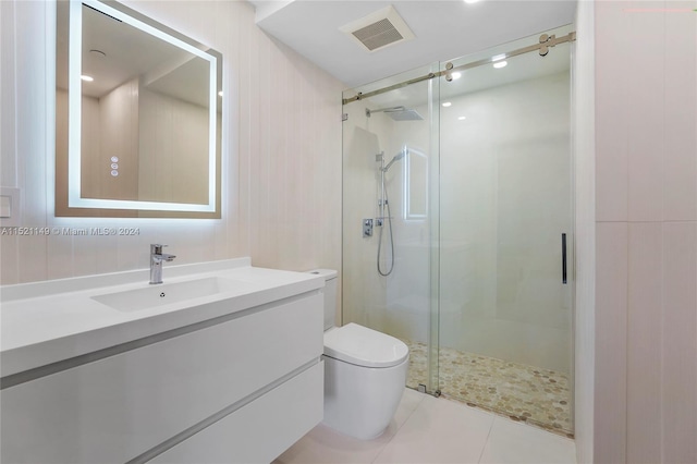 bathroom with toilet, vanity, a shower with shower door, and tile flooring