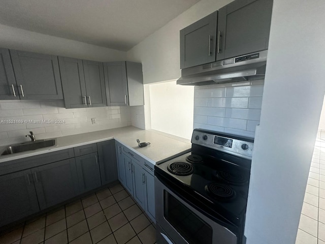 kitchen with sink, backsplash, gray cabinets, and electric range oven