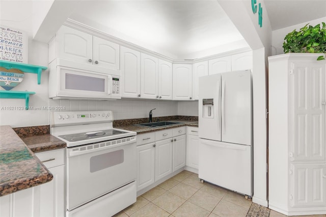 kitchen with light tile patterned flooring, sink, white appliances, and white cabinets