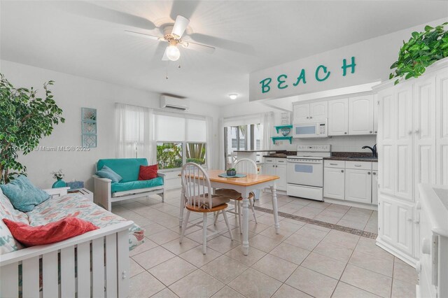 kitchen with white appliances, a wall mounted air conditioner, light tile patterned floors, sink, and white cabinetry