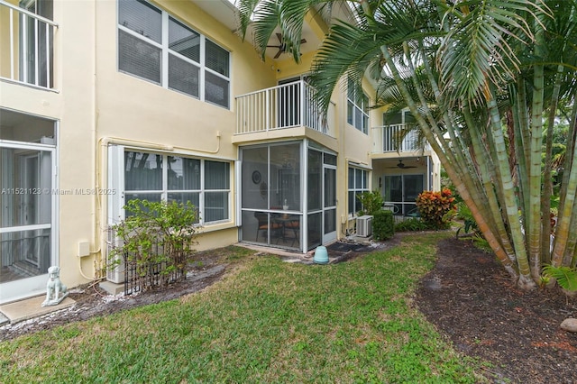 back of house with a yard, central air condition unit, and a sunroom