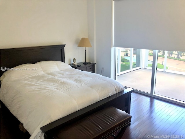 bedroom with dark hardwood / wood-style floors and access to exterior